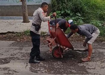 Pak Bhabin Bersama Warga Gotong royong Menutup Jalan Berlubang